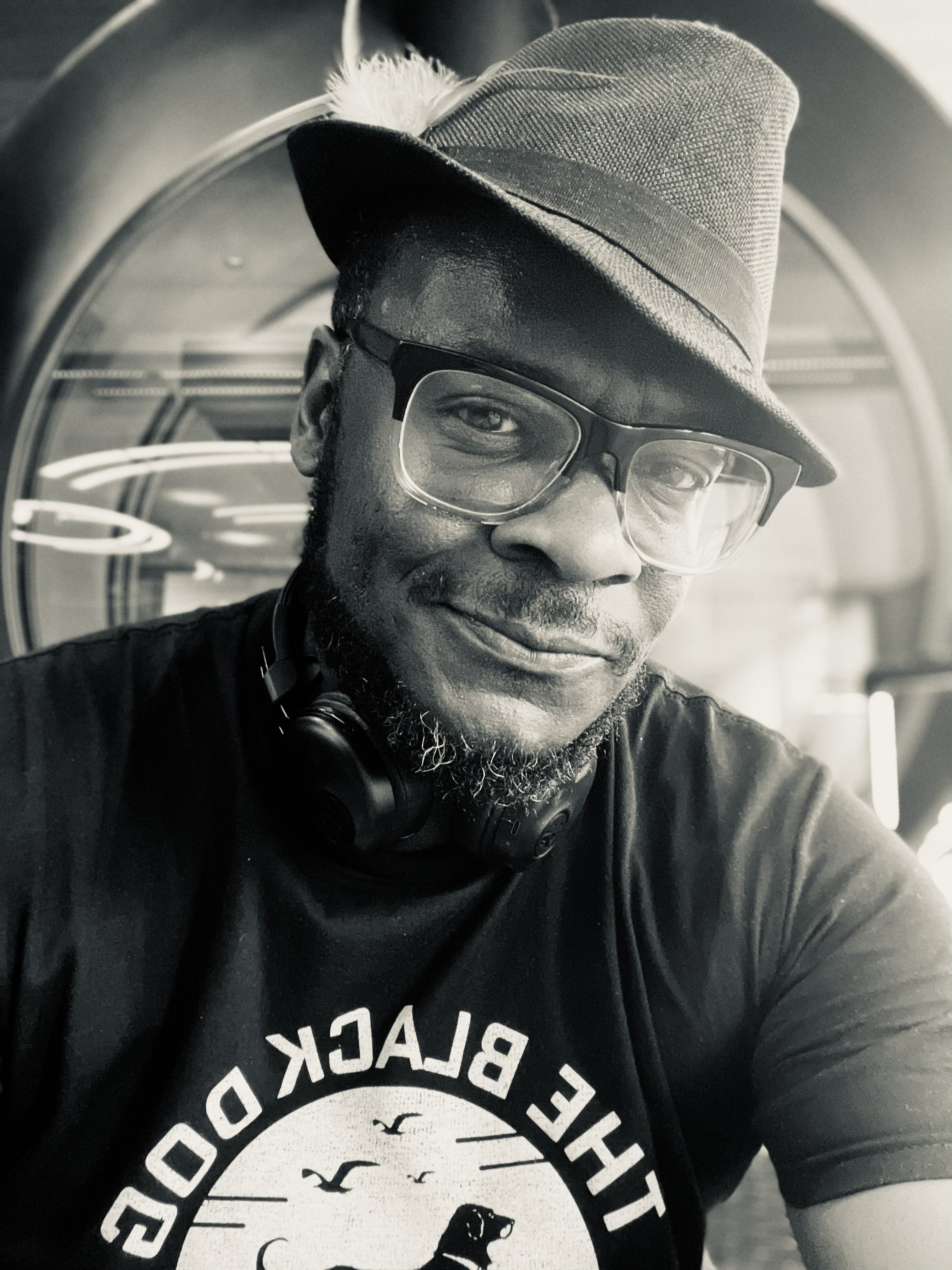 Black-and-white portrait of Earl Wyatt II wearing glasses and a hat