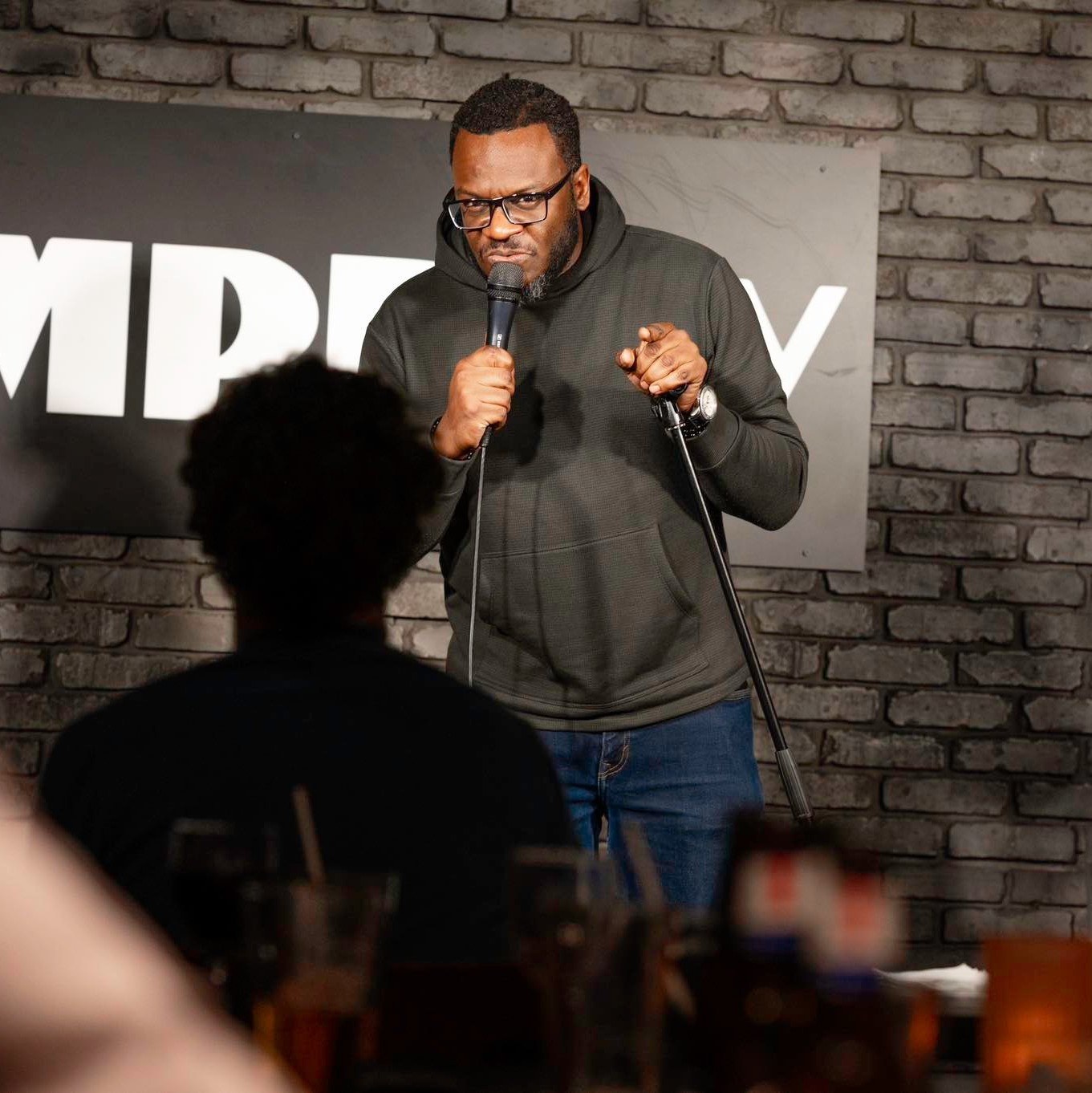 Earl Wyatt II performing at DC Improv, with audience members in the foreground